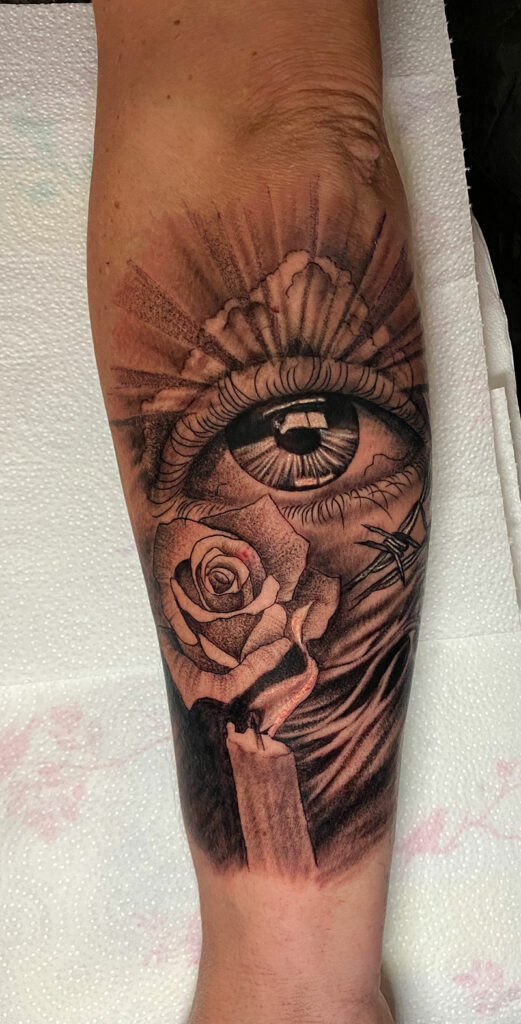 Auge, Rose und Kerze Tattoo am Arm